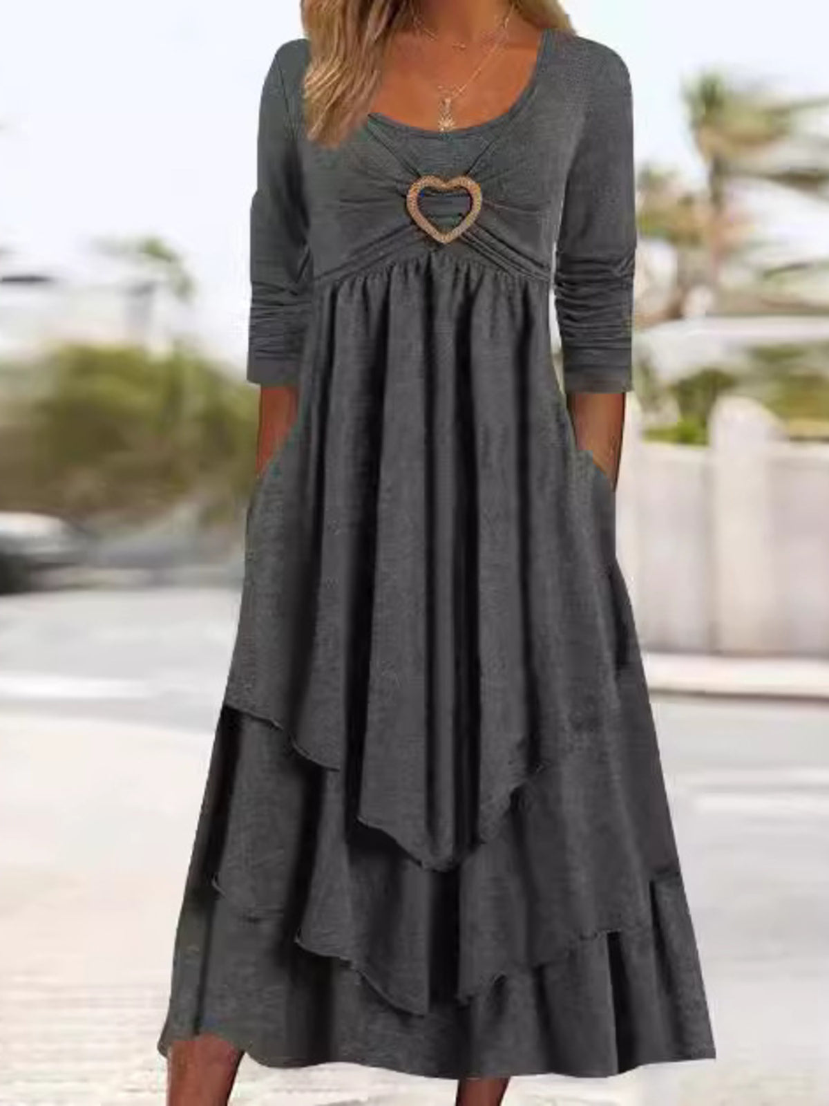 Dark gray tiered midi dress with long sleeves, scoop neck, and heart detail.