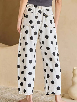 White polka dot denim jeans with high waist and visible bow details.