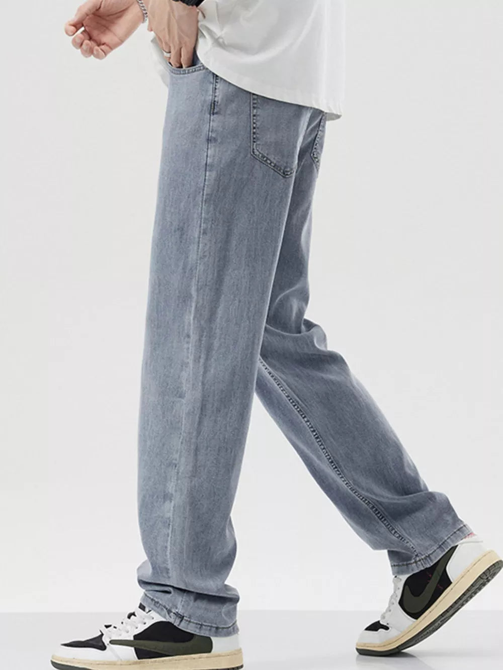 Relaxed fit wide-leg denim trousers in light blue, styled casually with sneakers.