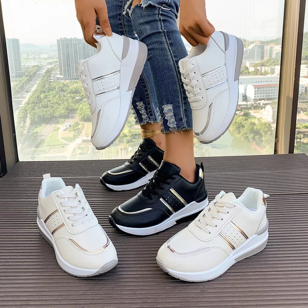 White and black lace-up sneakers with metallic accents and chunky soles