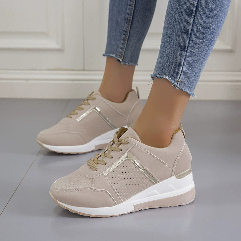 Beige lace-up wedge sneakers with metallic accents and perforated details.