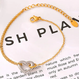 Gold two-tone heart charm bracelet with a delicate chain and lobster clasp.