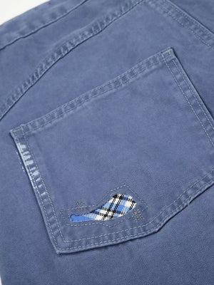 Blue faded cargo capris with distressed detailing and plaid pocket accent.