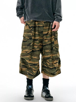 Oversized cotton camo cargo shorts in olive brown with multiple pockets and a relaxed fit.