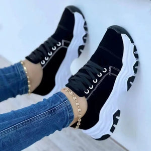 Black chunky sole lace-up sneakers with white soles and laces.