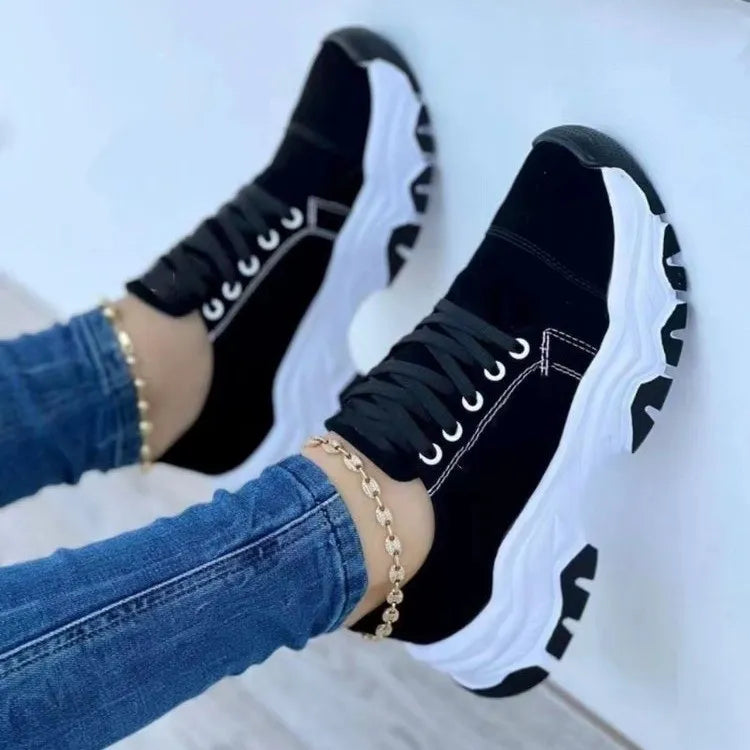 Black chunky sole lace-up sneakers with white soles and laces.