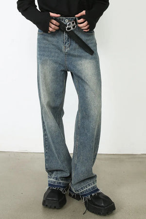 Distressed wide-leg denim jeans in medium wash with raw hem and a black belt.