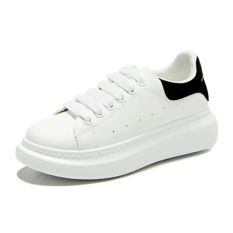 White platform sneakers with black suede heel detail and white laces