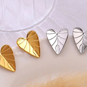 Gold and silver heartleaf stud earrings with detailed vein design.