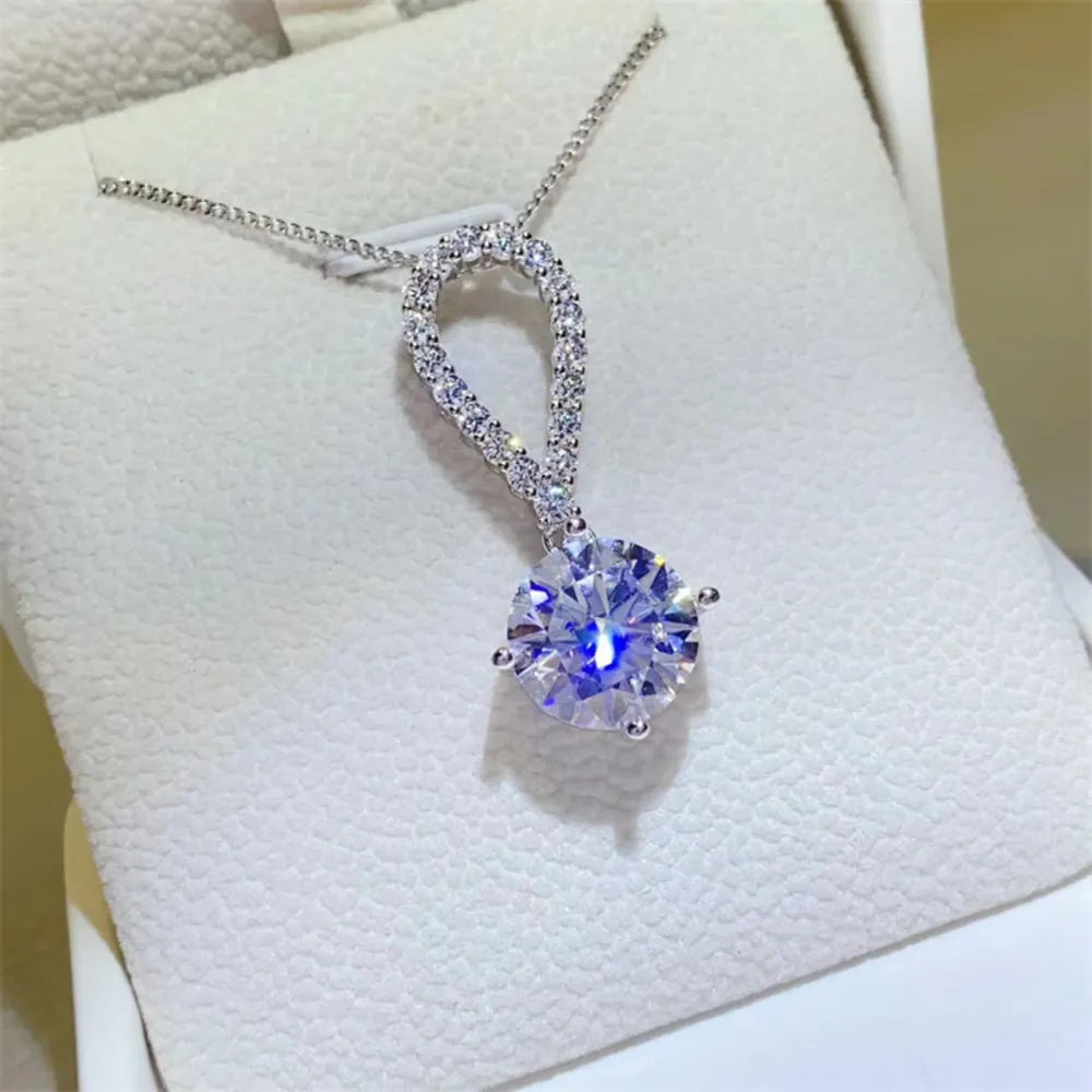 Silver pavé halo solitaire pendant necklace with a large round-cut center stone.
