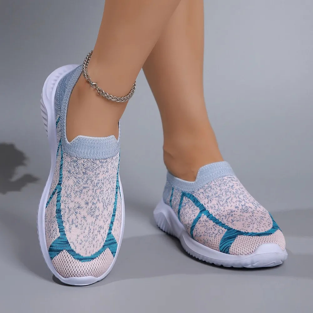 Geometric knit slip-on trainers in light gray with blue accents and white soles.