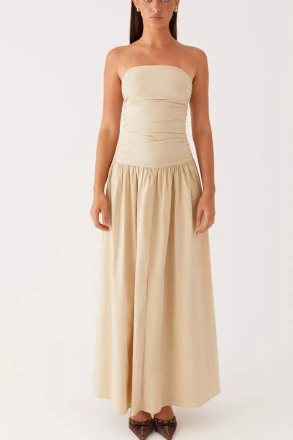 Ruched strapless maxi dress in cream with a flowing skirt and gathered waist detail.
