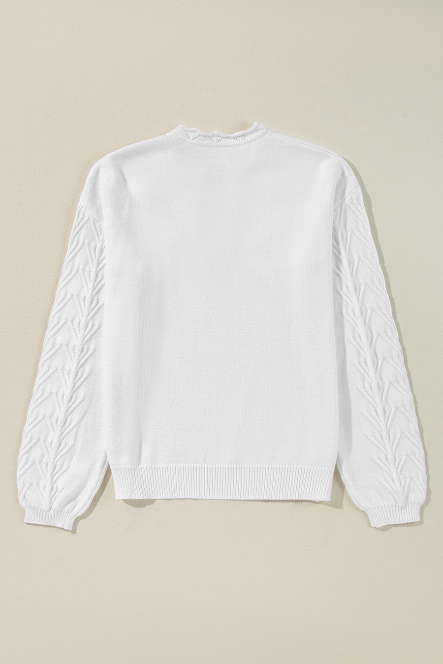 White knit sweater with textured leaf pattern on sleeves and scalloped notch neck.