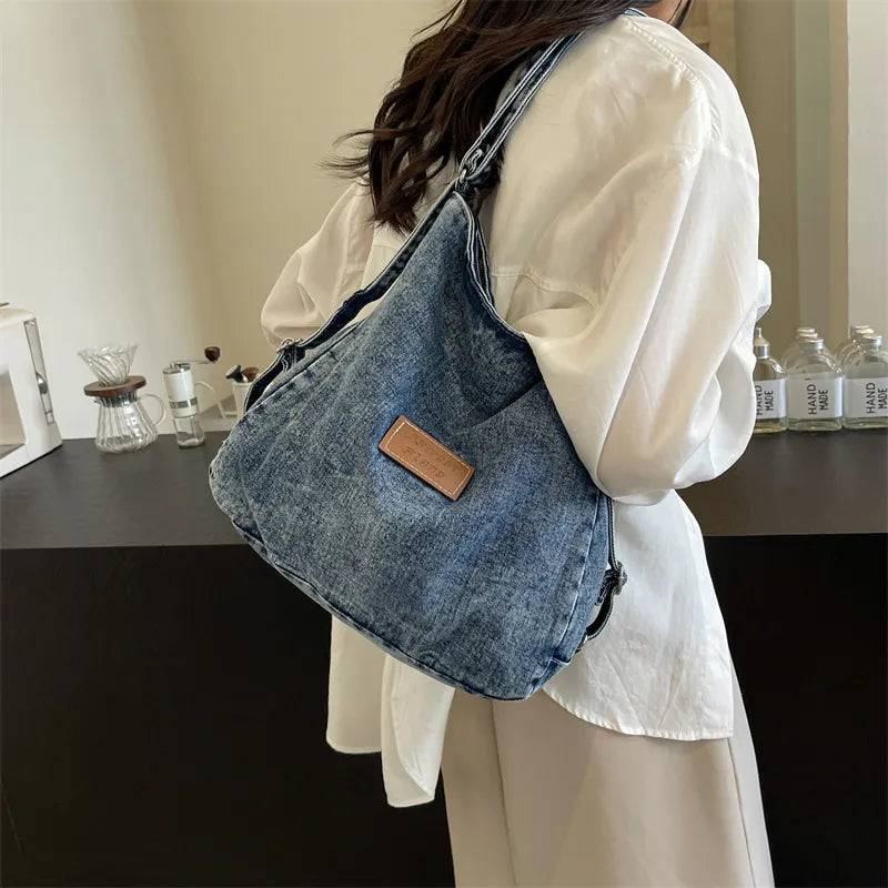Denim hobo bag in medium wash with leatherette patch detail.