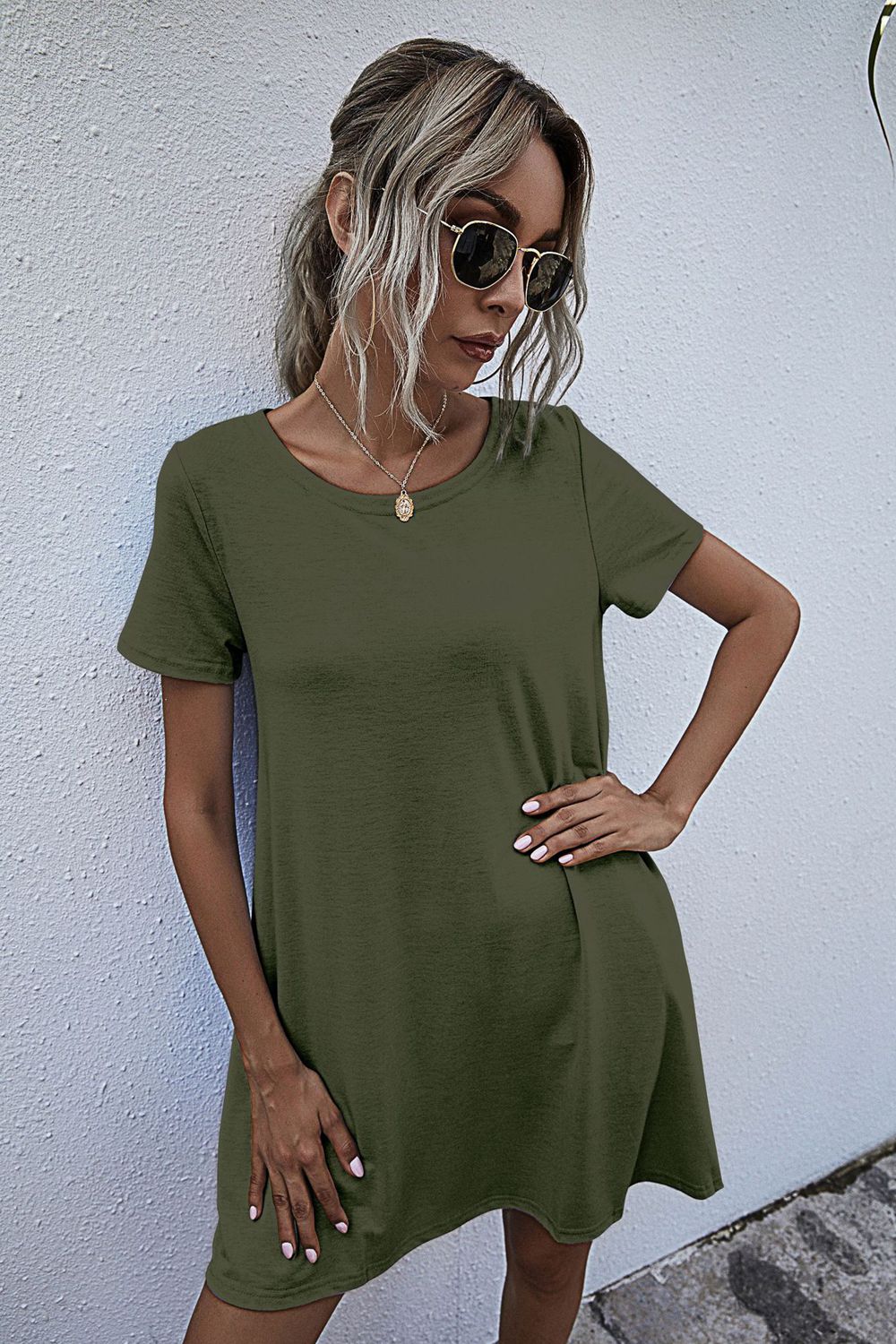 Army green relaxed tee dress with short sleeves and pockets, styled casually.
