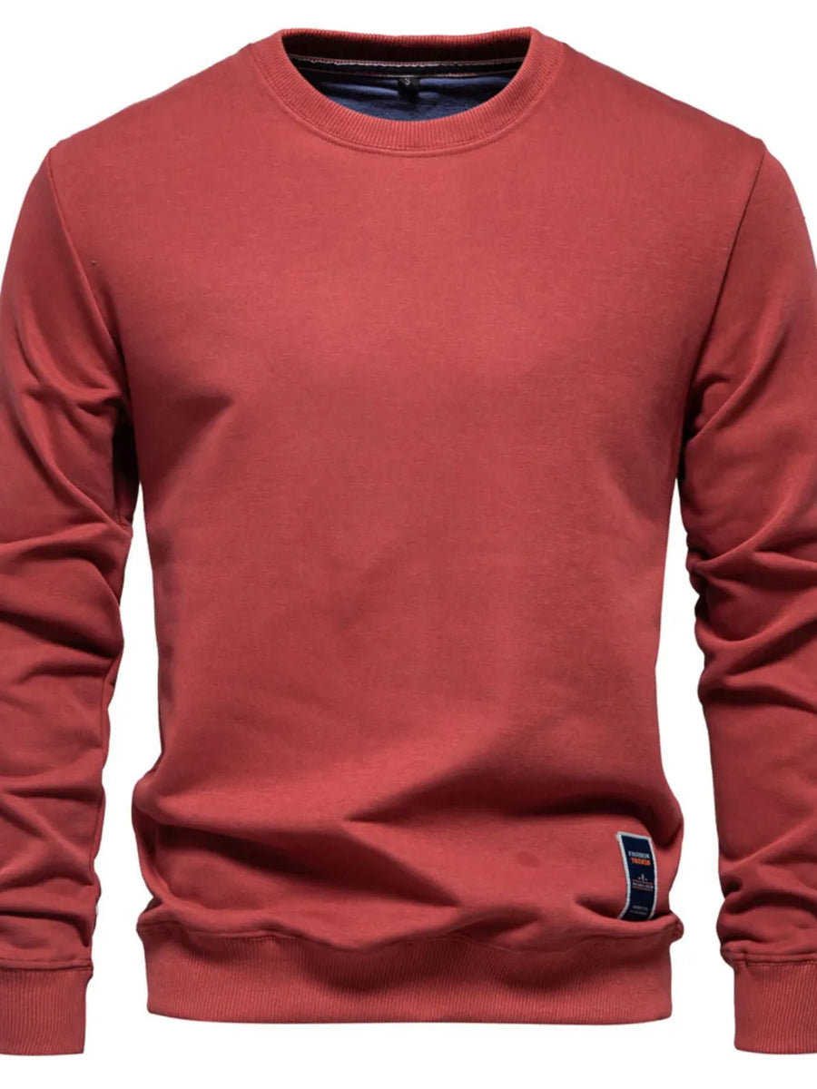 Deep Red crewneck sweatshirt with subtle patch detail on hem