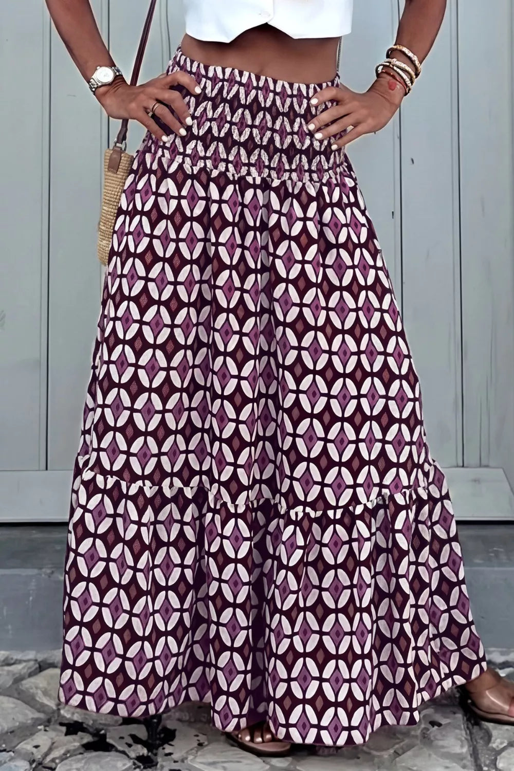Maxi skirt with geometric print, smocked waist, and tiered ruffle hem in purple and white.