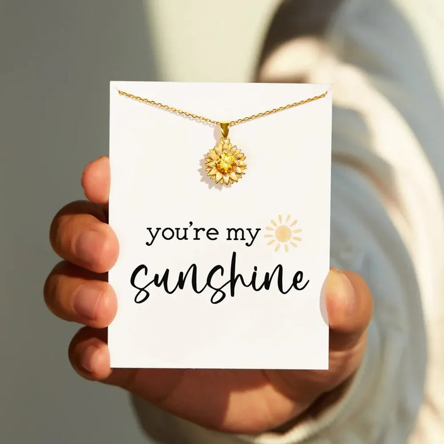 Gold sunflower pendant necklace with yellow gem detail on a card that says "you're my sunshine.