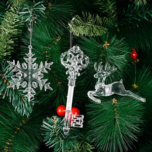 Clear snowflake, key, and reindeer Christmas ornaments hang on a tree.