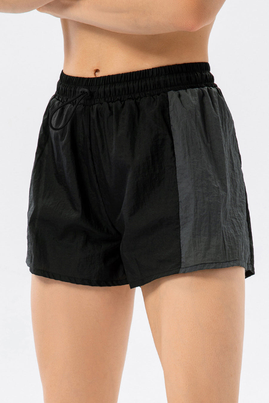 Black and dark grey colorblock performance running shorts with drawstring waist.