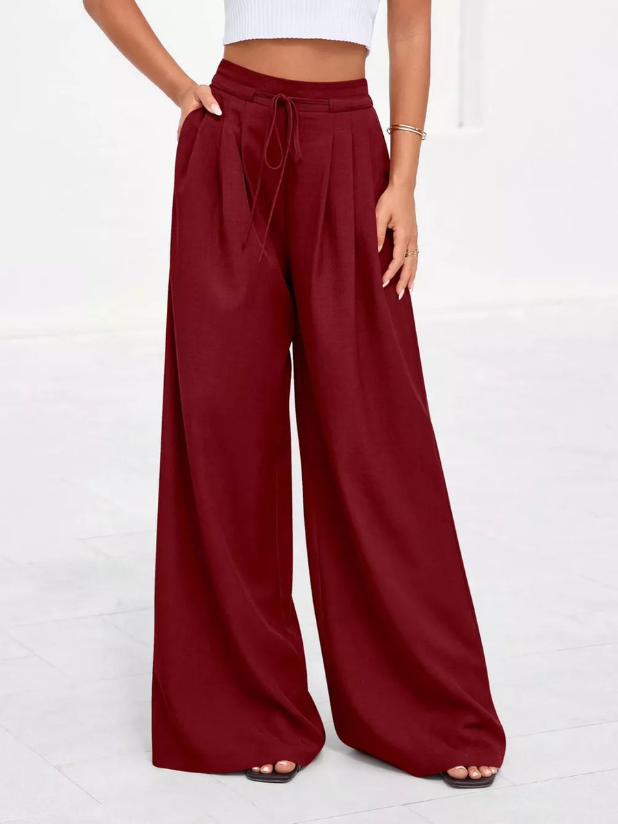 Burgundy high-waisted pleated wide-leg pants with pockets and drawstring waist