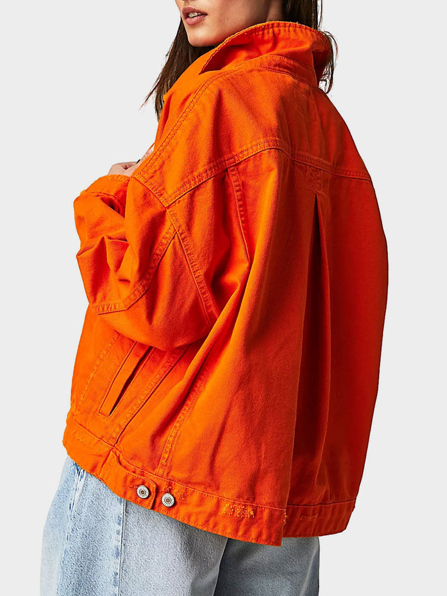 Sunset orange denim trucker jacket with button details and a relaxed fit.