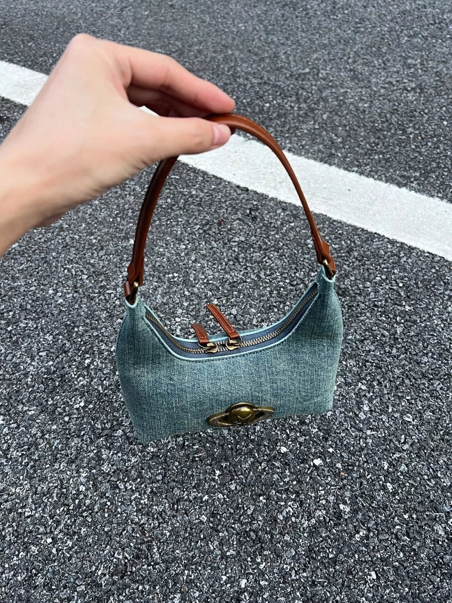 Mini denim shoulder bag with brown leather strap and gold hardware detail.