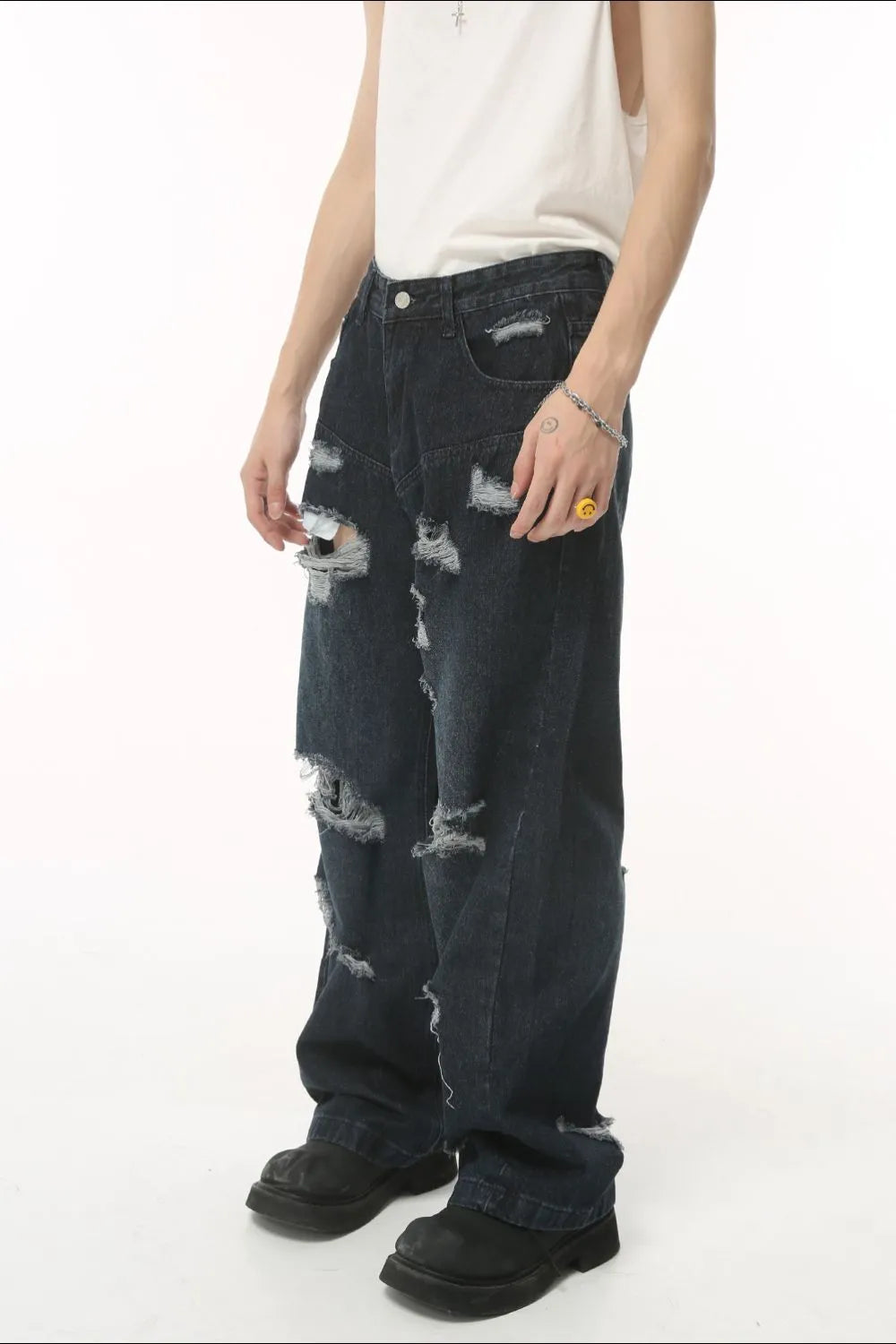 Distressed baggy dark wash denim jeans with statement rips and frayed hems.