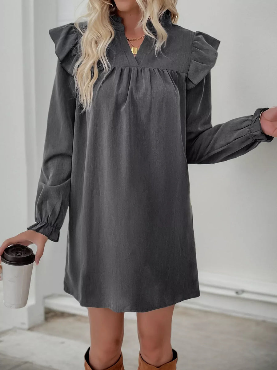 Dark gray cotton blend dress with ruffled shoulders, V-neck, and cinched cuffs.