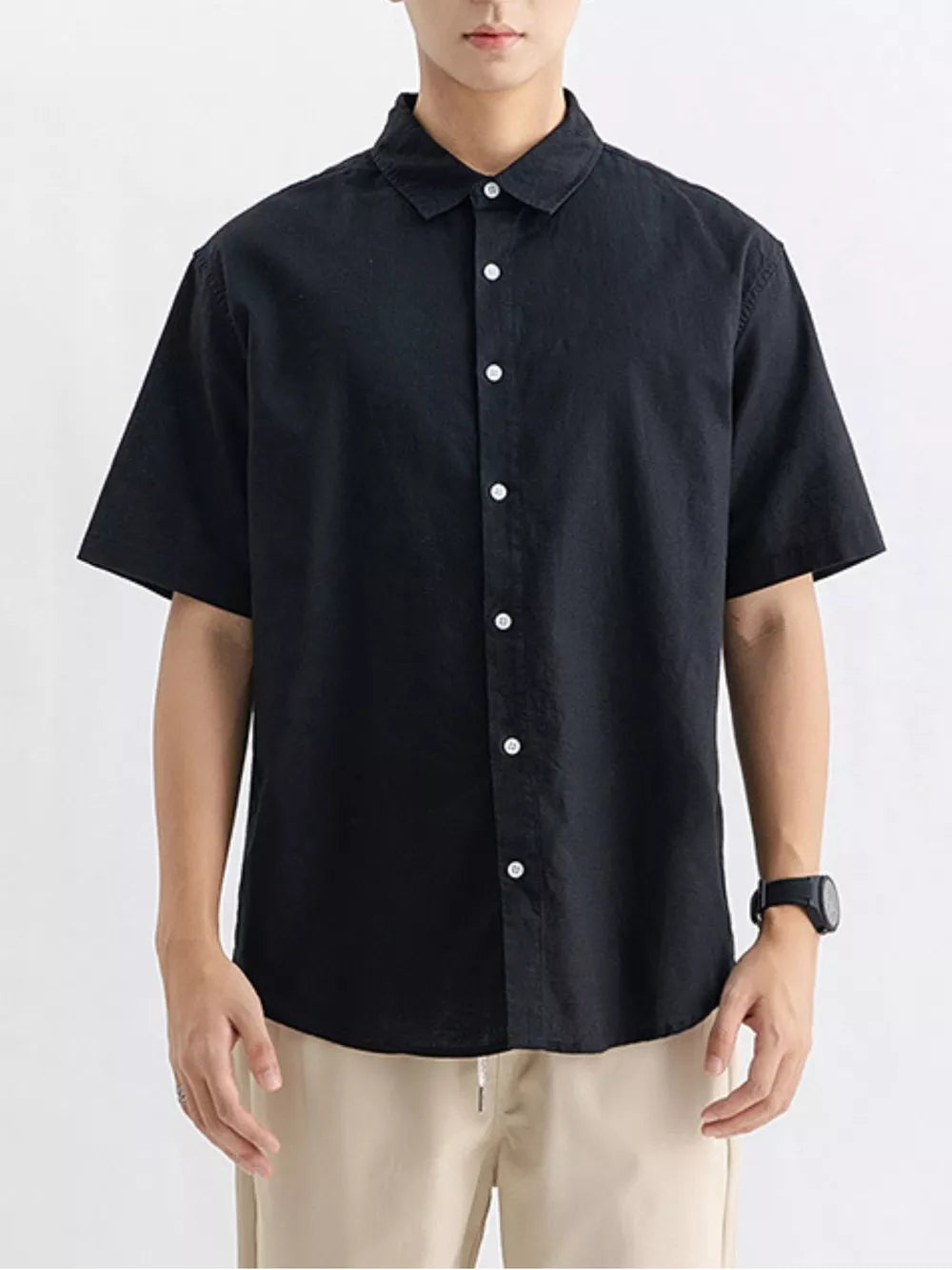 Black cotton button-up short sleeve overshirt with white buttons.
