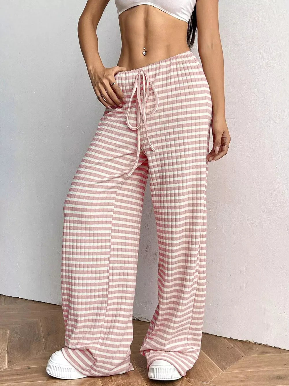 Pink striped ribbed wide-leg pants with drawstring and white sneakers