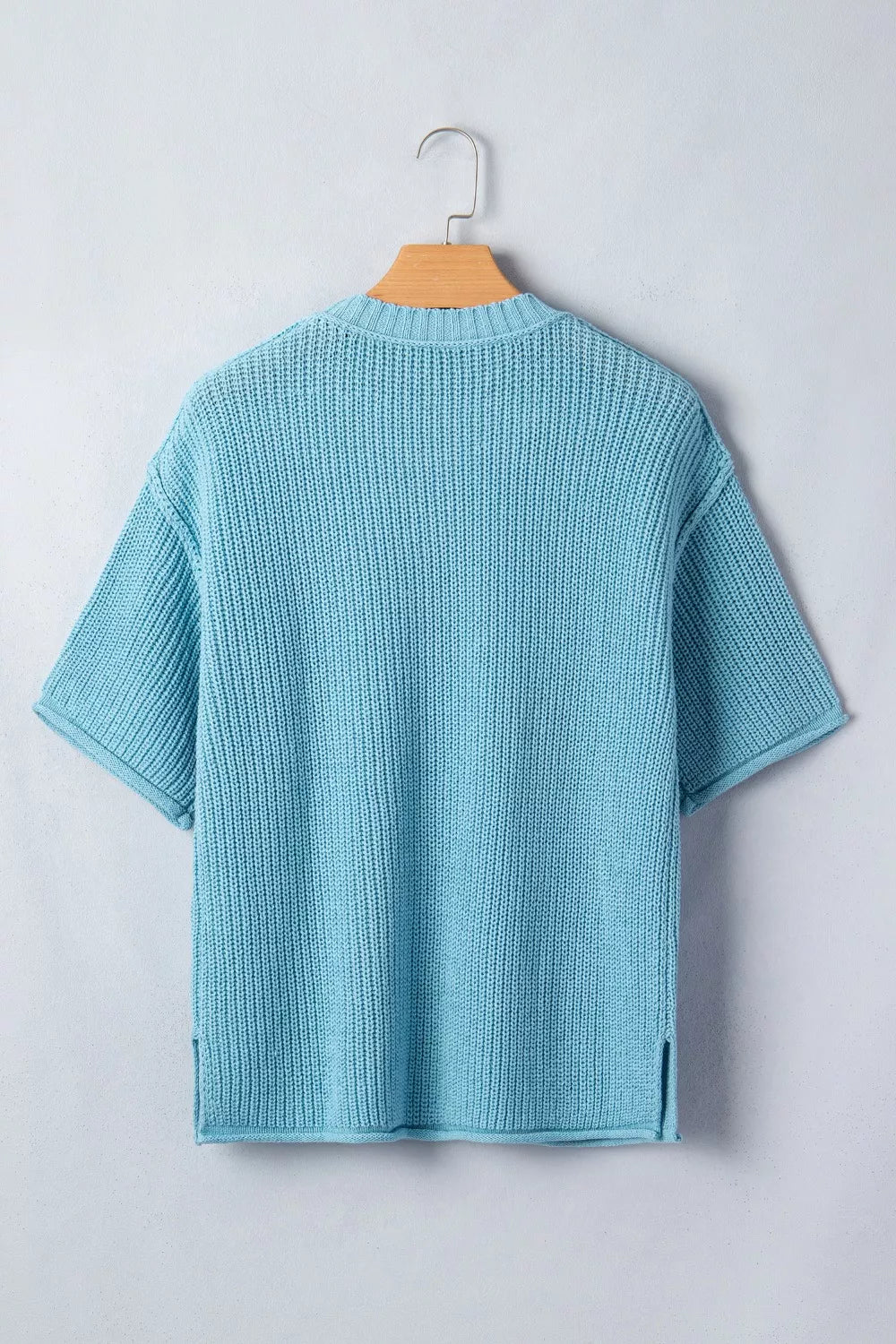 Relaxed ribbed knit sweater top in light blue with short sleeves and side slits.