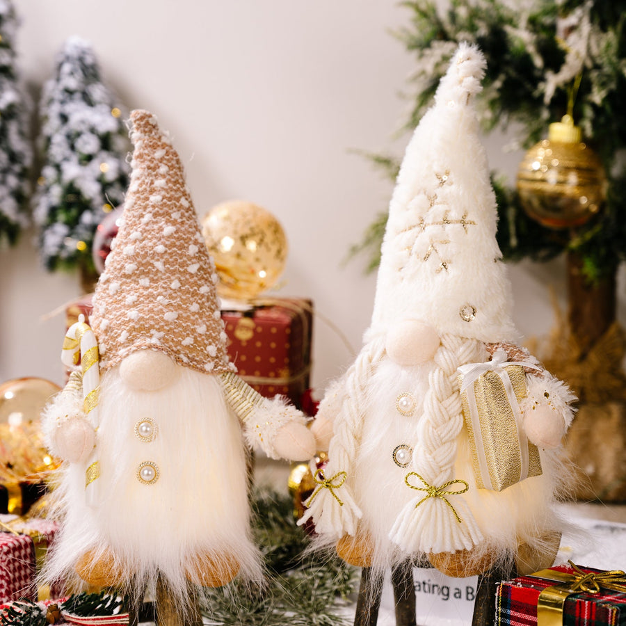 Illuminated festive gnomes, one male with candy cane, one female with gift, battery-operated holiday decor.