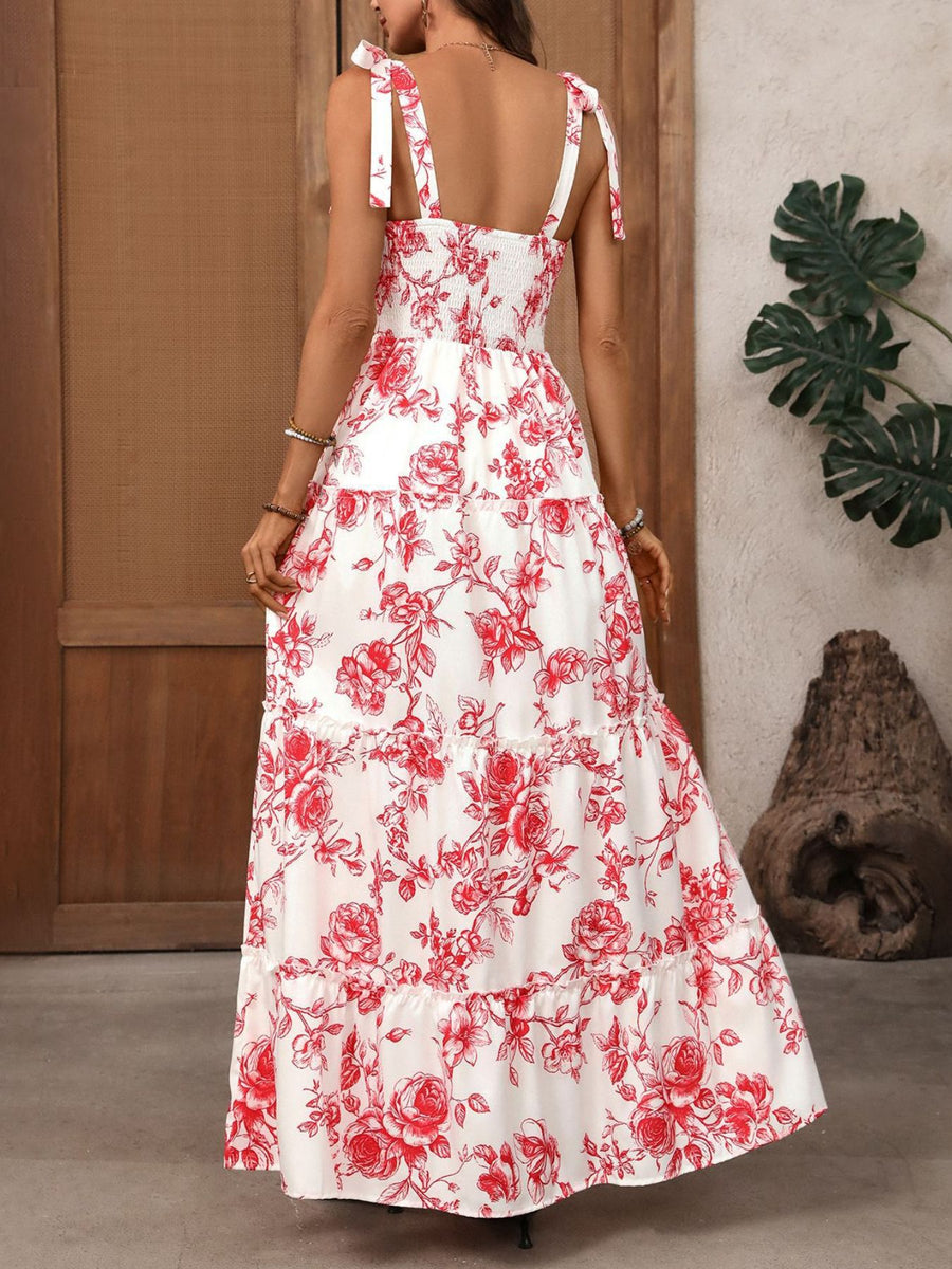 White maxi dress with red floral print, tie straps, smocked bodice, and tiered skirt.