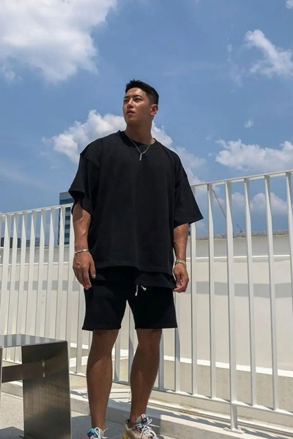 Black oversized drop-shoulder tee with short sleeves and a crew neck.