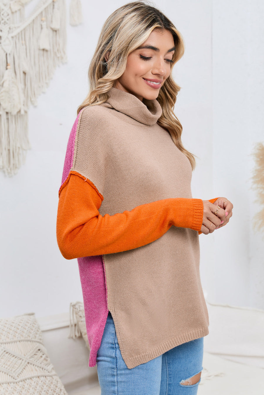 Colorblock knit turtleneck sweater in tan with orange and pink sleeves and side panels.