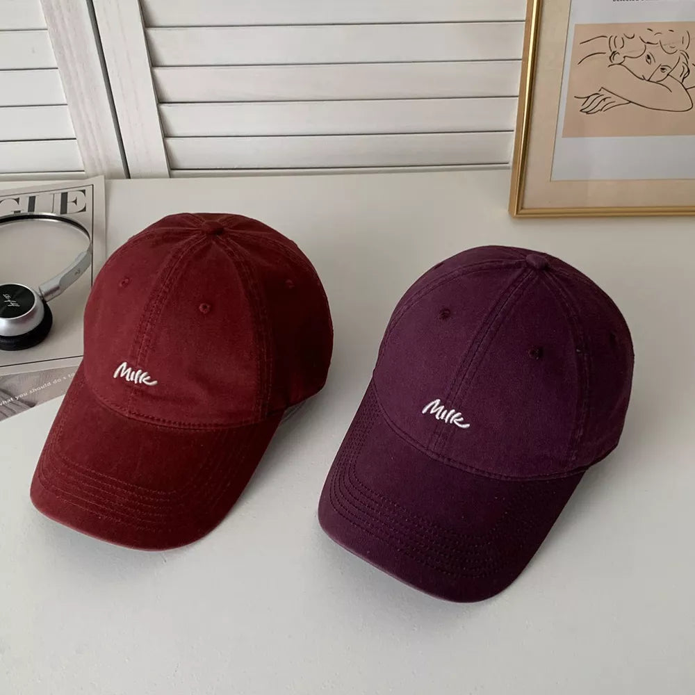 Baseball cap in wine red and purple with embroidered "Milk" detail