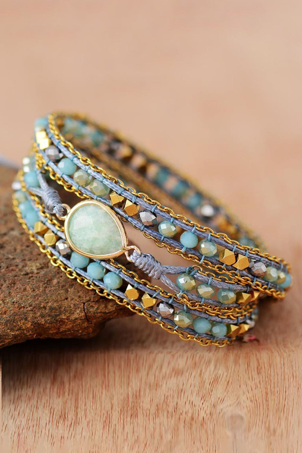 Aqua beaded wrap bracelet with gold chain and teardrop gemstone detail.