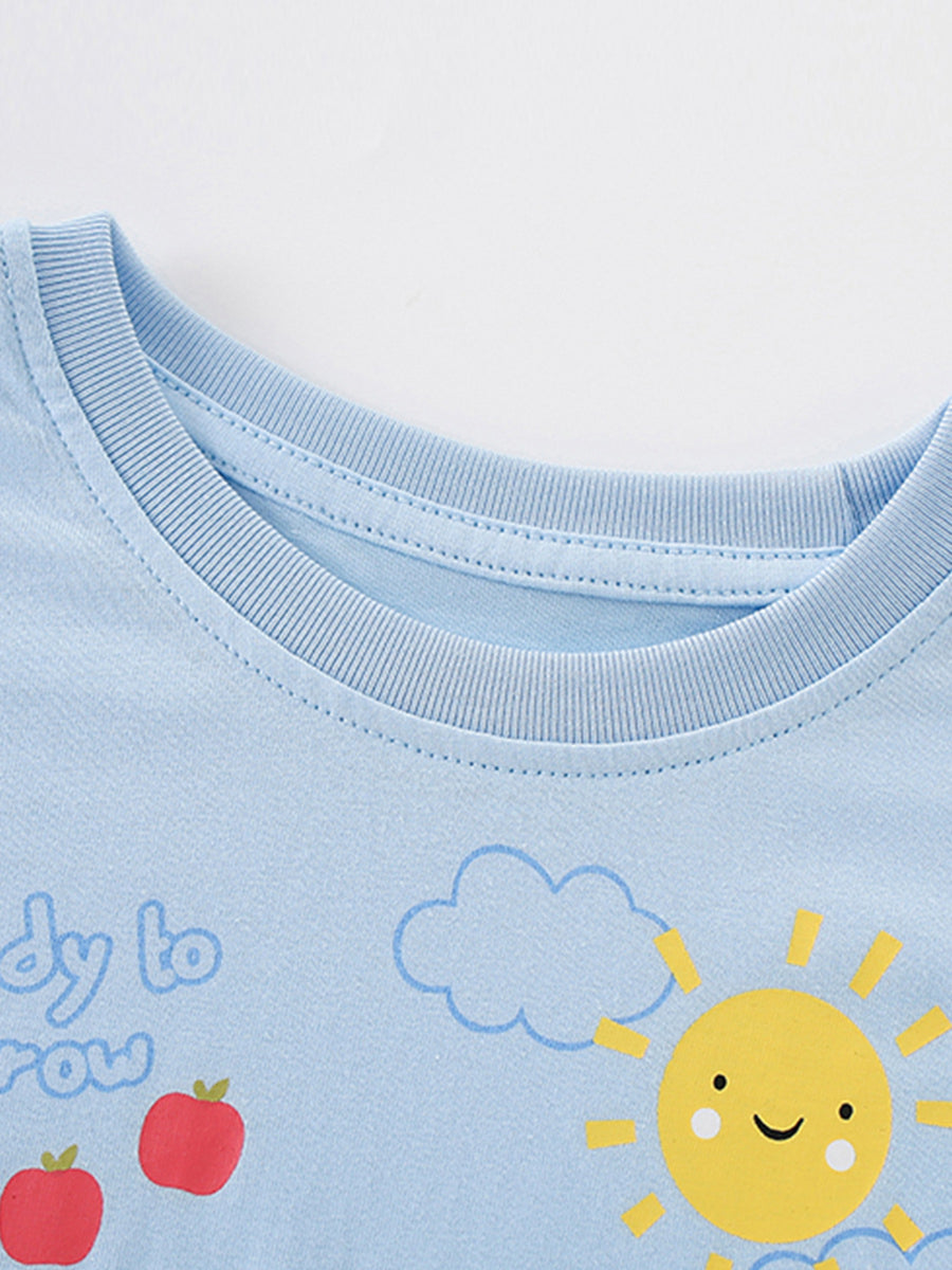 Light blue cotton t-shirt with cartoon sun, clouds, apples and text graphic.