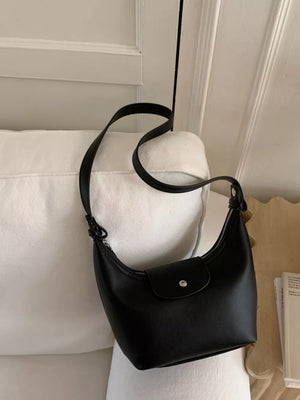 Black mini crescent hobo bag with a flap closure and silver snap.