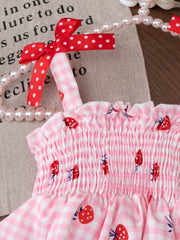 Pink smocked strawberry top with white gingham and red polka dot bows.