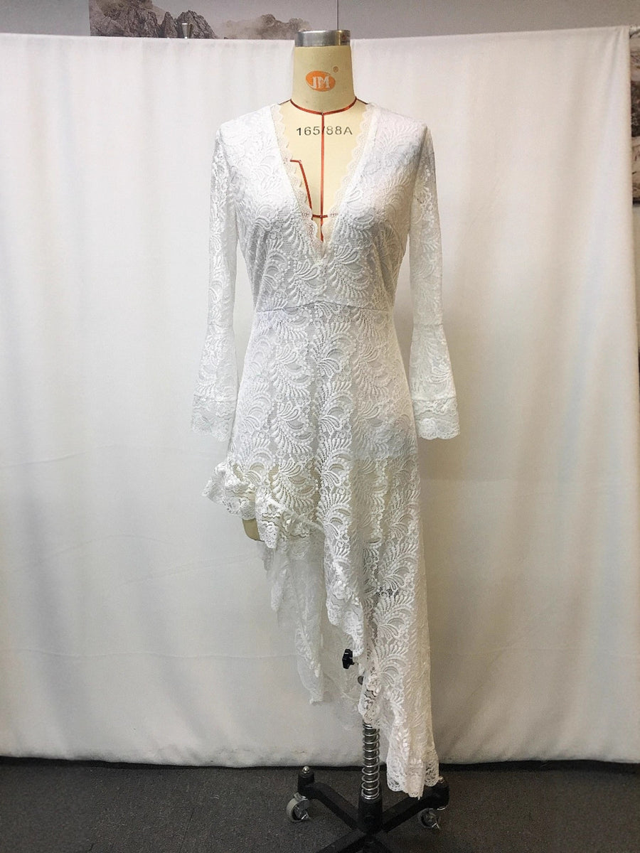 White lace asymmetrical V-neck dress with bell sleeves and ruffled hem.