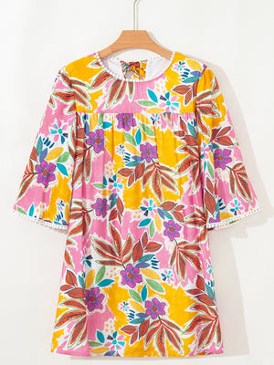 Print bell sleeve mini dress with colorful floral pattern and pom-pom trim.