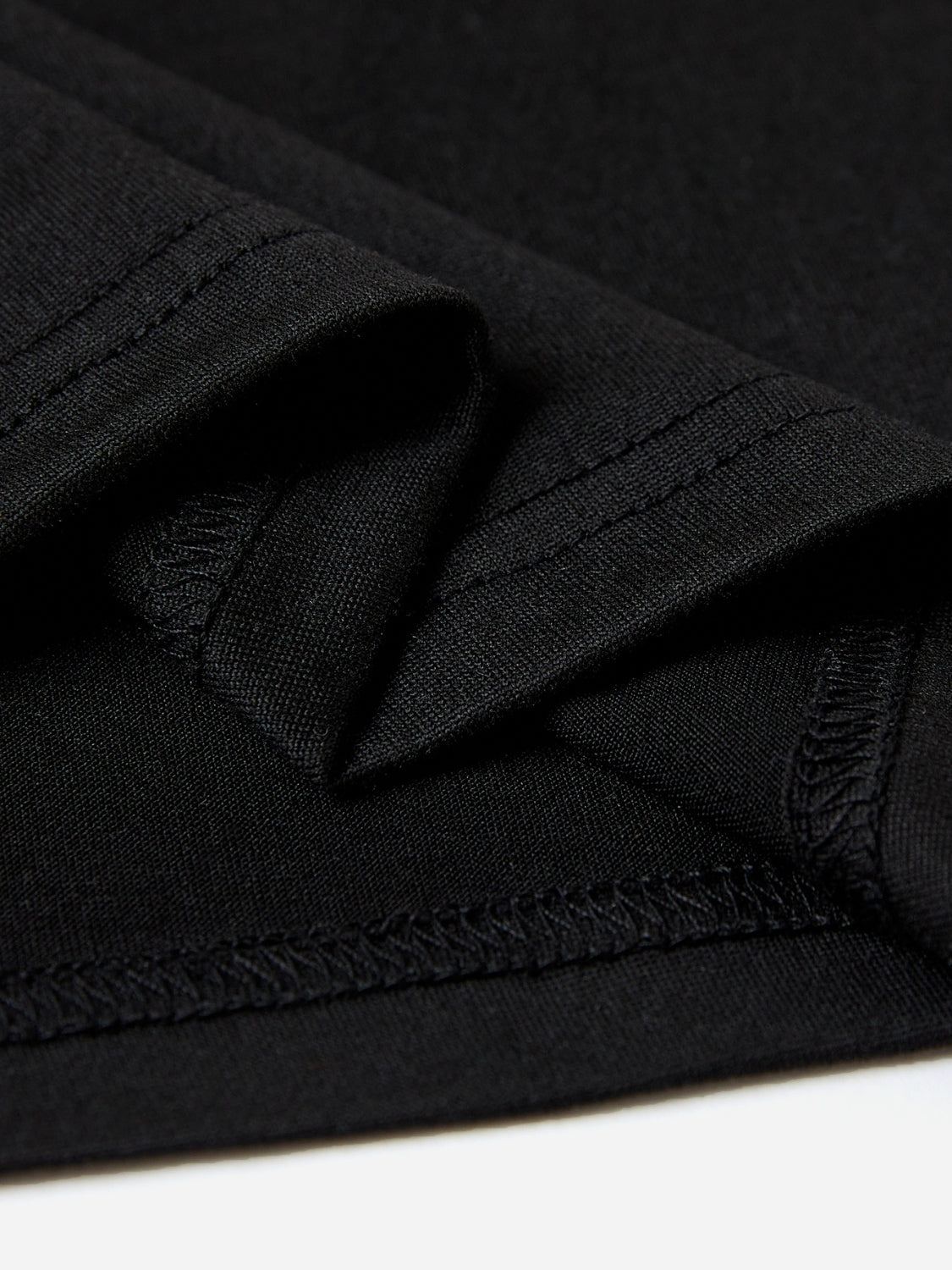 Black t-shirt with visible stitching detail on hem and seams