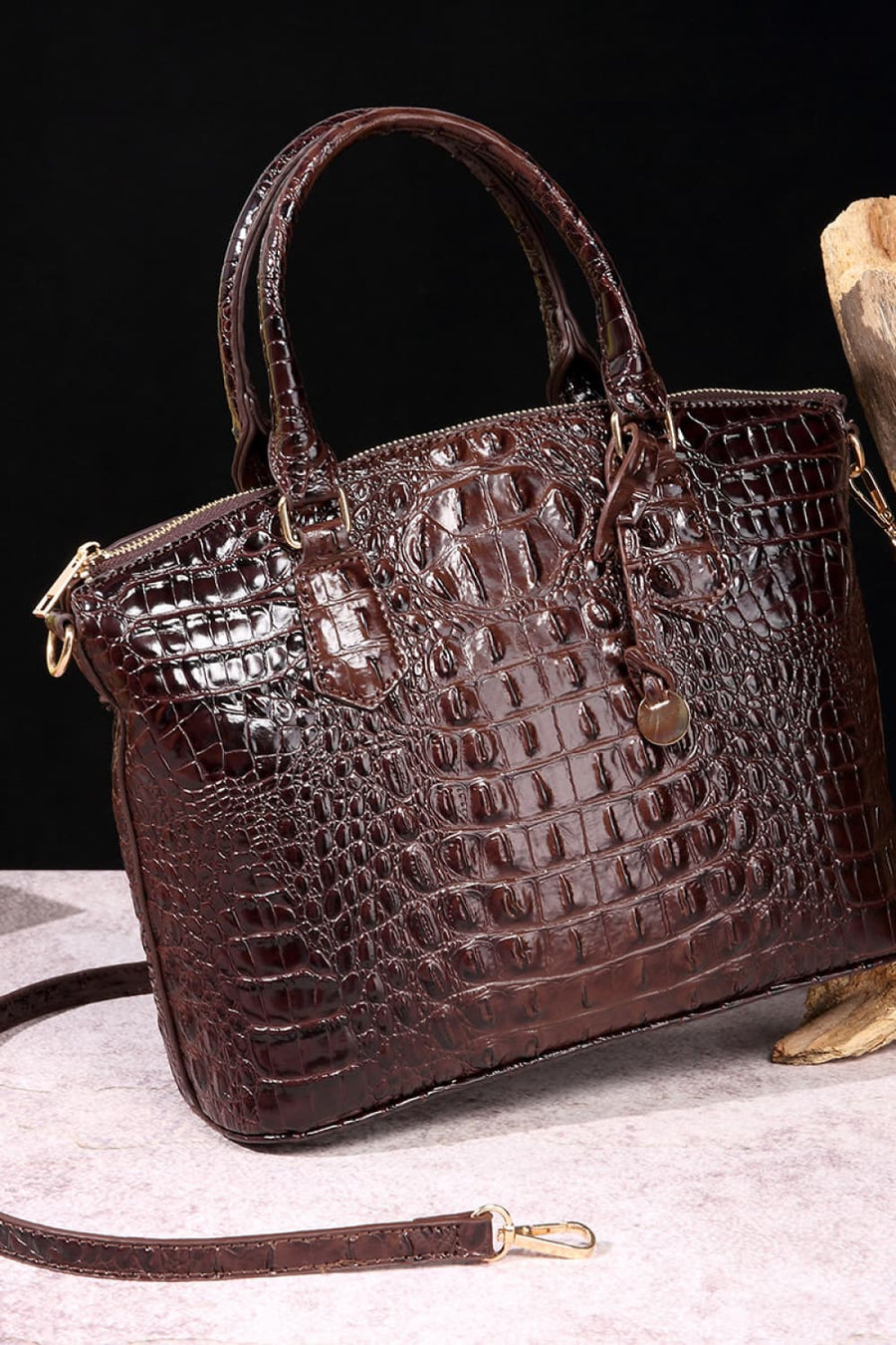 Brown crocodile embossed satchel bag with top handles and shoulder strap.