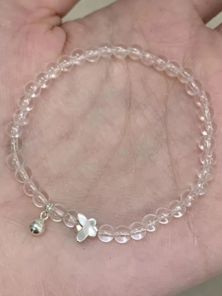 Clear crystal beaded bracelet with silver butterfly charm and bell dangle.