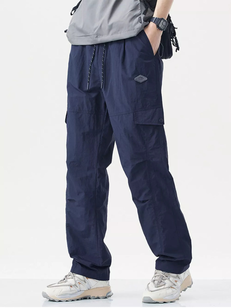 Navy blue relaxed fit cargo sweatpants with drawstring and patch detail.