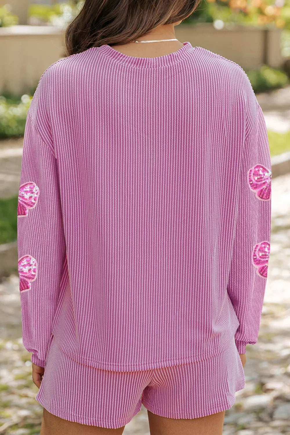 Pink striped two-piece set with sequin bow detail on sleeves