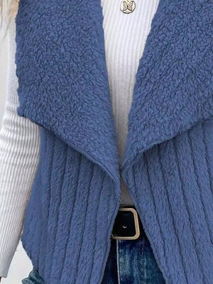 Blue fleece vest with open front and shawl collar, textured material.