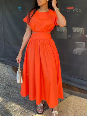 Orange crop top and maxi skirt set with short sleeves and a high waist.